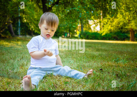 Portrait of Cute petit garçon avec le syndrome de jouer dans la nature Banque D'Images