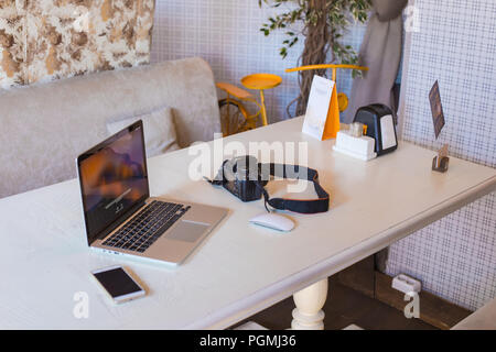 Ordinateur portable, téléphone, appareil photo sur un ordinateur de bureau moderne. Vue sur l'arrière-plan d'un bureau d'ordinateur portable et les appareils numériques dans un café. Banque D'Images