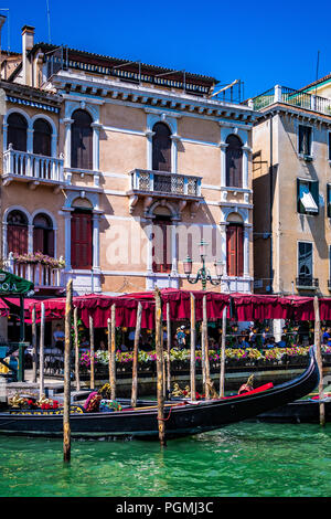 Une station de télécabine en face d'un restaurant animé à côté du Grand Canal à Venise, en Italie Banque D'Images