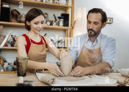 Homme barbu portant chemise rayée à la femelle à potter Banque D'Images