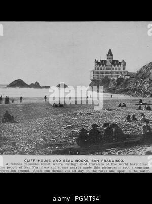 Photographie noir et blanc montrant les gens et des joints debout et assis sur une plage à l'avant-plan avec l'océan, les falaises, et Adolph Sutro's à la fin du xixe siècle, Cliff House Restaurant, un château victorien à plusieurs niveaux, dans l'arrière-plan, titré 'Cliff House et Seal Rocks, San Francisco, 1906. Avec la permission de Internet Archive. () Banque D'Images