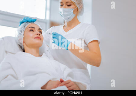 Femme sérieuse nice coiffeur se concentrant sur son travail Banque D'Images