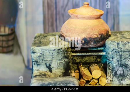 Salon avec cuisine locale Vintage ancien pot en porcelaine sur l'antique cuisinière et bois de chauffage Banque D'Images