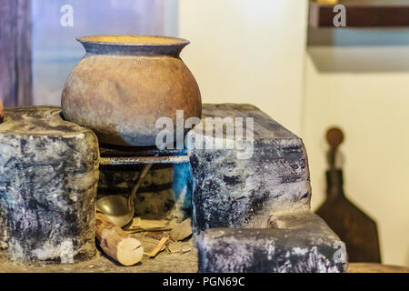 Salon avec cuisine locale Vintage ancien pot en porcelaine sur l'antique cuisinière et bois de chauffage Banque D'Images