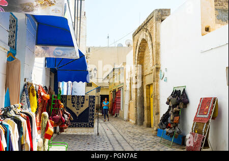 SOUSSE, TUNISIE - 28 août 2015 : les vêtements et les magasins de tapis autour de la porte médiévale de Zaouia Zakkar mosquée de Médine, le 28 août à Sousse. Banque D'Images