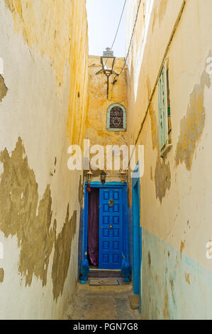 Logement de médina médiévale chaotique est riche en ruelles étroites et courbées avec de hauts murs et de petites portes en bois, Médina, Sousse, Tunisie. Banque D'Images