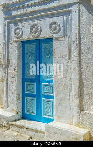 Le bleu porte de bois de vieux chalet, décorées avec des motifs floraux et entouré de plâtre porte secours, Mahdia, Tunisie. Banque D'Images