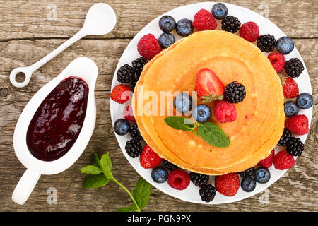 Pile de crêpes avec différents fruits rouges isolé sur fond blanc. Vue d'en haut. Mise à plat Banque D'Images