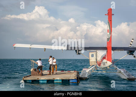 Les Maldives, 10 février 2018 - Un hydravion attendent les touristes dans un bois près de la plate-forme offshore Hilton Hôtel à Maldives. L'eau bleu, ciel nuageux, ensoleillé Banque D'Images