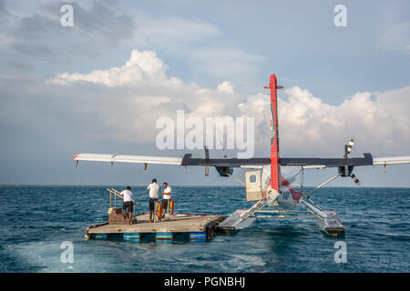 Les Maldives, 10 février 2018 - Un hydravion attendent les touristes dans un bois près de la plate-forme offshore Hilton Hôtel à Maldives. L'eau bleu, ciel nuageux, ensoleillé Banque D'Images