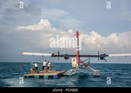 Les Maldives, 10 février 2018 - Un hydravion attendent les touristes dans un bois près de la plate-forme offshore Hilton Hôtel à Maldives. L'eau bleu, ciel nuageux, ensoleillé Banque D'Images