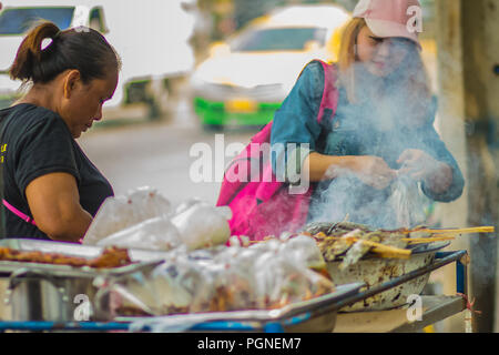 Bangkok, Thaïlande - 22 Février, 2017 : Street food vendor poissons cuisson du poulet fumé et sur four Banque D'Images