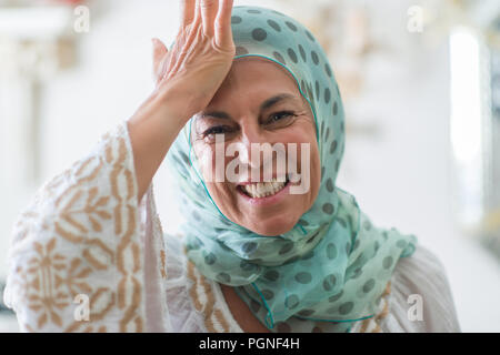 L'âge moyen d'arabie brunette woman wearing hijab coloré a souligné avec la main sur la tête, choqué par la honte et la surprise face, en colère et frustrés. La peur Banque D'Images