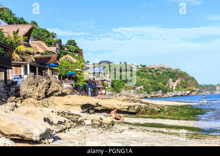 Bali, Indonésie - 30 mai 2017 : Les gens en train de bronzer sur la plage de Bingin. La plage est rocheuse avec un peu de sable mainy. Banque D'Images