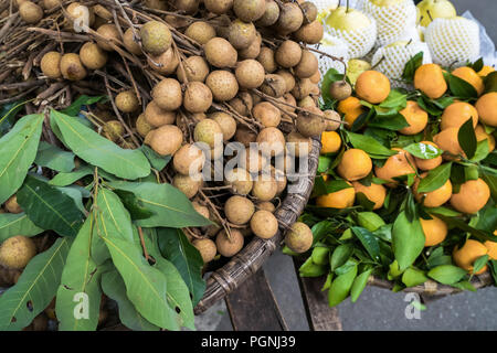 Divers types de fruits vendus à partir des paniers de pendaison traditionnels peuvent se trouver à Hanoi, Vietnam. Banque D'Images