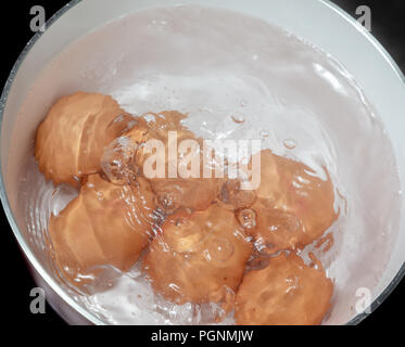 Six oeufs l'ébullition dans une casserole sur une plaque à induction Banque D'Images