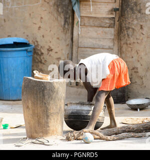 GHANI, GHANA - Jan 14, 2017 : petite fille ghanéenne non identifiés se penche pour laver ses mains dans le village Ghani. Le Ghana d'enfants souffrent de la pauvreté en raison Banque D'Images