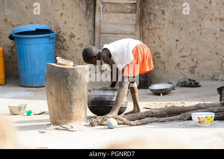 GHANI, GHANA - Jan 14, 2017 : petite fille ghanéenne non identifiés se penche pour laver ses mains dans le village Ghani. Le Ghana d'enfants souffrent de la pauvreté en raison Banque D'Images