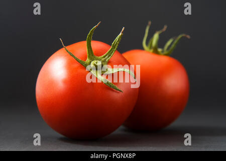 Les tomates de groupe isolé sur noir avec des feuilles et des tiges. Il y a environ 7 500 variétés de tomates cultivées à des fins diverses.variétés de tomates peuvent être div Banque D'Images