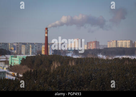 Kemerovo, Russie - 30 janvier 2018 - De la fumée sort de la cheminée de chauffage et d'électricité entouré par une forêt et multi-étages Banque D'Images