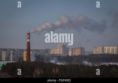 Kemerovo, Russie - 30 janvier 2018 - De la fumée sort de la cheminée de chauffage et d'électricité entouré par une forêt et multi-étages Banque D'Images