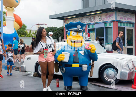 Femme debout à côté d'une figure de chef Wiggum près de The Simpsons Ride at Springfield USA, Universal Studios Florida - Orlando, Floride USA Banque D'Images