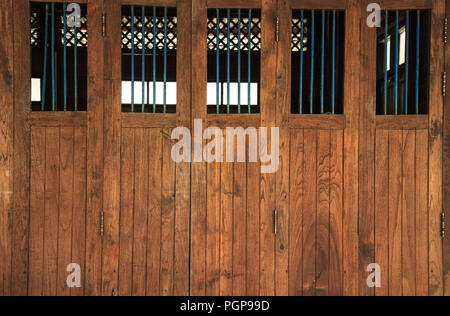 Vintage Retro portes en bois et fenêtres avec bars, home design architectural intérieur contre lisse brun foncé tropical carte du panneau de bois texturé Banque D'Images