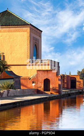 Beaux jardins de la Menara Marrakech Maroc bâtiments avec reflets dans la piscine. Orange, Jaune plâtre avec des toits de tuiles vertes, des arches. Close up. Banque D'Images