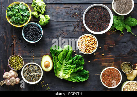 Les graines, les céréales, les haricots, l'air et les légumes verts sur table en bois foncé dessus. concept de nourriture de régime végétarien ou Banque D'Images