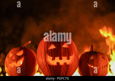 Symboles d'Halloween terrifiant - Jack-o-lanternes. Scary Halloween pumpkins sculpté sur fond noir flammes de feu. All Hallows' Eve ou All Saints' E Banque D'Images