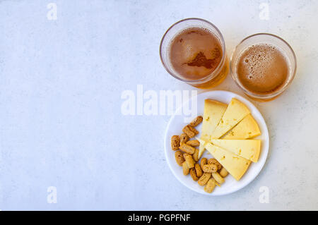 Deux verres de bière, fromage et craquelins, côté droit, vue d'en haut Banque D'Images
