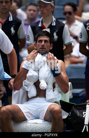 New York, États-Unis. Août 28, 2018. Flushing Meadows, New York - 28 août 2018 : US Open de Tennis : nombre de graines 6 Novak Djokovic se drape dans des serviettes mouillées au cours d'un passage dans un effort pour lutter contre la chaleur lors de son premier match contre Marton Fucsovics du Mexique à l'US Open à Flushing Meadows, New York. Les températures ont été dans les années 90, à New York aujourd'hui, comme Djokovic a remporté le match en quatre sets à l'avance à la deuxième ronde. Crédit : Adam Stoltman/Alamy Live News Banque D'Images