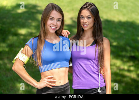 Portrait de deux belles filles et de repos actif smiling après l'extérieur de la formation sur une journée ensoleillée dans le parc Banque D'Images