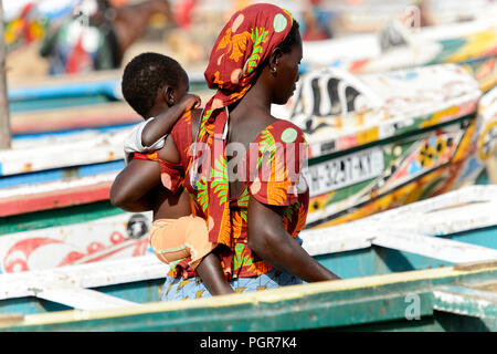 KAYAR, SÉNÉGAL - AVR 27, 2017 : femme sénégalaise non identifié porte un bébé sur la côte de l'océan Atlantique. De nombreuses personnes travaillent au port de Kayar Banque D'Images