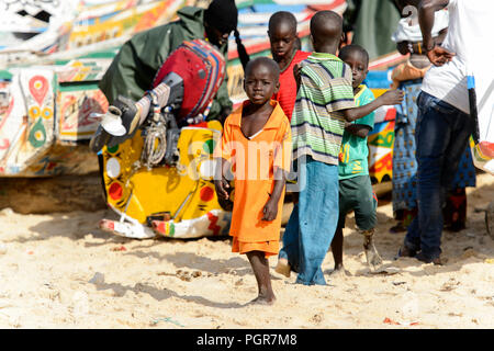 KAYAR, SÉNÉGAL - AVR 27, 2017 : petit garçon sénégalais non identifiés en costume orange promenades sur la côte de l'océan Atlantique. De nombreuses personnes travaillent dans Kayar p Banque D'Images