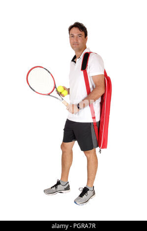Un beau jeune homme debout dans son costume de tennis, raquette et balles isolées pour fond blanc détendu et souriant Banque D'Images