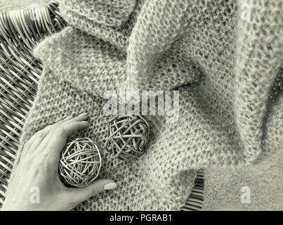 Servante sur la chaise à carreaux avec les deux boules en bois woman's hand holding l'un d'eux l'image de l'intérieur noir et blanc Banque D'Images