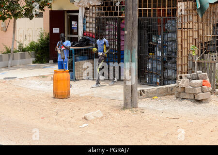 LAC ROSE reg., SÉNÉGAL - AVR 27, 2017 : deux garçons sénégalais non identifiés à pied près du stock avec les matériaux de construction. Encore beaucoup de personnes vivent au Sénégal Banque D'Images