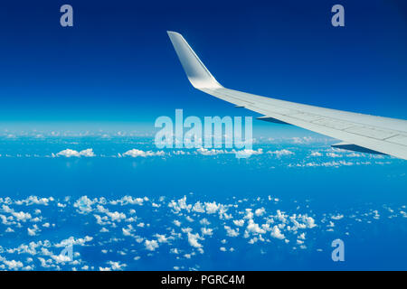 En regardant par la fenêtre de l'avion pendant le vol. L'aile plus de ciel bleu et nuages blancs.Copier l'espace. Banque D'Images