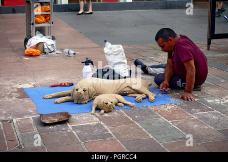 Artiste de rue, la création de sculptures de sable de chiens sur Buchanan Street, Glasgow Banque D'Images