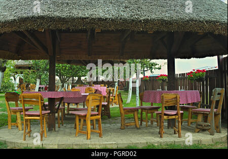 Vintage conçu table et chaises en bois sous abri de canne Banque D'Images