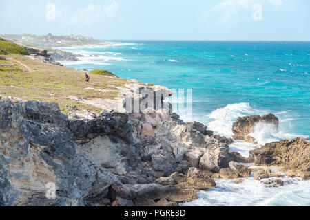 Un homme près d'une falaise au bord de l'océan sur l'Isla Mujeres. Banque D'Images