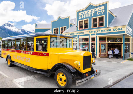 L'Skagway en Alaska Rue Voiture tour bus passant l'Alaska Shirt Co. à Skagway, Alaska USA Banque D'Images