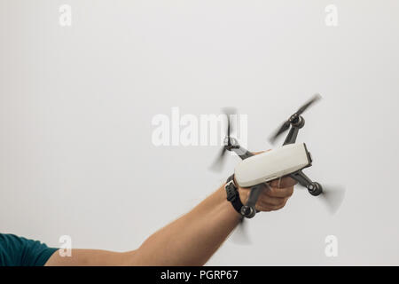 Le petit dron attire l'homme dans sa main. L'atterrissage Dron Banque D'Images