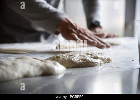 La fabrication du pain : dans un restaurant cuisine le chef se met à faire de la baguette traditionnelle appelée Ficelle - le mot français pour chaîne Banque D'Images