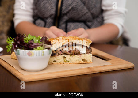 Un steak sandwich sur pain focaccia avec une salade. Banque D'Images