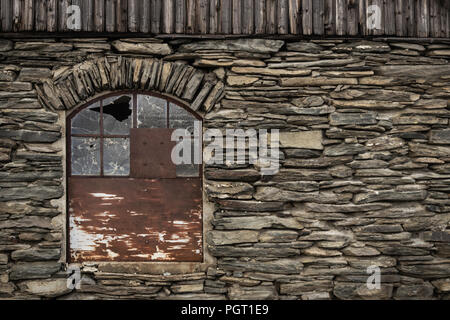 Un mur de briques et d'une vitre cassée sur une ancienne maison dans Storwartz, juste à l'extérieur de Røros, la Norvège. Banque D'Images
