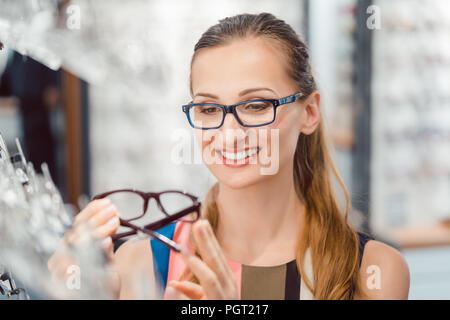 Femme être satisfaits des nouvelles lunettes qu'elle a acheté dans le magasin Banque D'Images