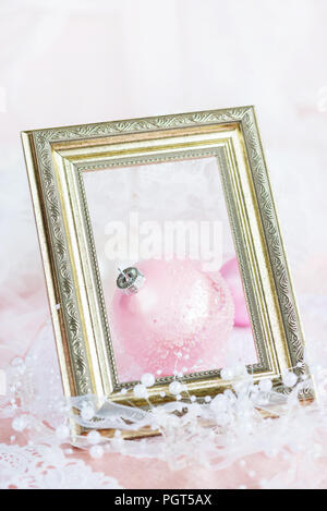 Belle décoration de Noël : grand bal de Noël rose avec un ruban blanc et perles dans un cadre vintage doré sur un fond clair, avec l'espace f Banque D'Images