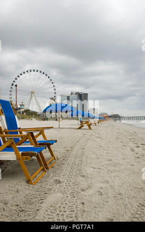 Chaises et parasol bleu vide la ligne de mer sur une morne journée à Myrtle Beach SC USA Banque D'Images